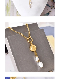 Détail d'un collier doré avec médaille en nacre et deux perles blanches pendantes