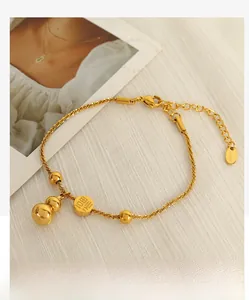Detail of gold gourd charm and Fu character pendant on stainless steel twisted chain