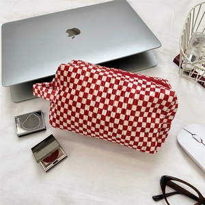 Detail of red and white checkered velvet makeup bag with textured bubble fabric