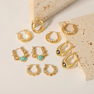 18K gold plated stainless steel evil eye and pearl hoop earrings collection on stone