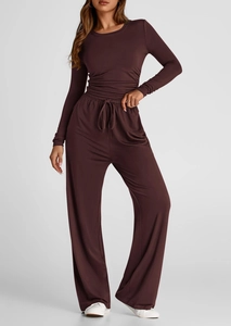 Dettaglio dei pantaloni a gamba larga con coulisse e top a maniche lunghe color cacao