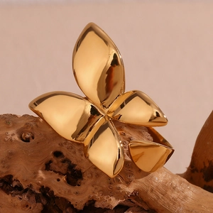 Detailed view of butterfly ring in 18K gold plated finish on natural wood background