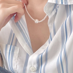 Minimalist 925 sterling silver pearl necklace worn over a blue striped shirt