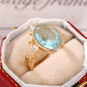 Gros plan d'une bague vintage dorée avec pierre ovale bleue dans son écrin rouge