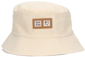 Close-up of leather patch with smile icon and Beil Kiss text on beige bucket hat