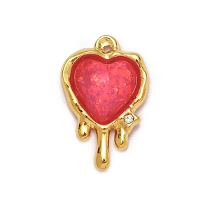 Macro shot of gold-plated red sequin heart pendant with a crystal drip detail