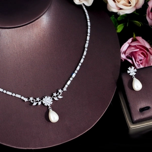 Detail of pearl jewelry set with zircon necklace and teardrop earrings on neck model