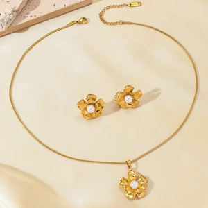 Macro detail of French vintage pearl camellia necklace set with gold flower earrings
