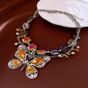 Detailed macro view of vintage butterfly pendant with amber rhinestones and luxury beads