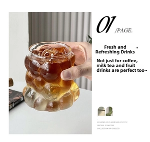 Close-up of hand holding creative bubble textured clear glass cup for iced coffee