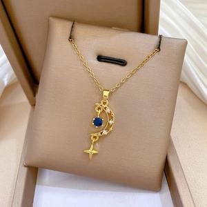 Detailed macro shot of a gold moon and star pendant with a deep blue gemstone inlay