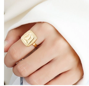 Detail of 18k gold plated ring featuring a unique ripple textured square design on model
