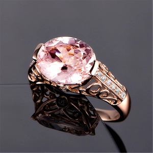 Macro detail of oval pink morganite gemstone on rose gold hollow-out ring with diamond accents