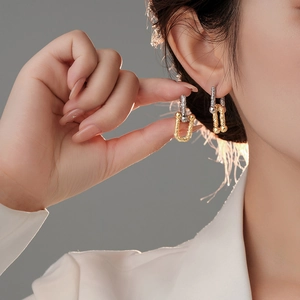 Minimalist two-tone horseshoe hoop earrings with textured relief on u-shaped link