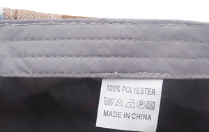 Macro shot of the interior sweatband and polyester care label on the plaid beret hat
