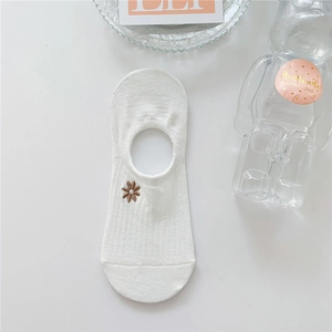 Close-up of white cotton invisible boat sock featuring delicate brown floral embroidery detail