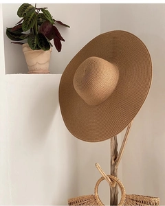 Détail de la texture d'un chapeau de paille tissé à la main sur un support en bois naturel