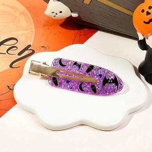 Detail of purple glitter Halloween hair clip with RIP coffin design on white tray