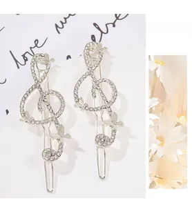 Detailed view of silver treble clef hair clips with pavé crystals and 3D butterflies