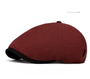 Close-up of burgundy mesh newsboy cap showing textured knit fabric and black brim