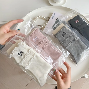 Detail of ruffle trim socks with bow embroidery in white, pink, grey and black set
