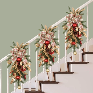 Christmas teardrop swag with gold leaves and red berries on white stairs