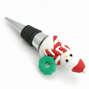 Close-up of a snowman wine stopper with red scarf and green wreath on a polished metal base