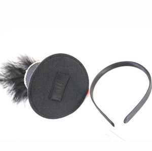 Detailed view of black mini top hat with feather decor and matching headband set