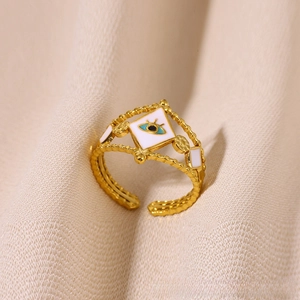 Macro detail of gold adjustable ring featuring white enamel diamond and blue evil eye charm