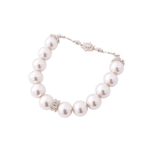 Elegant white pearl bracelet with zircon flower charm and silver metal accents on white background