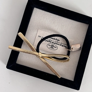 Elastico per capelli con fiocco in metallo dorato in una scatola di legno