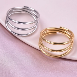 Three-layer spiral stainless steel rings in gold and silver on a silk background