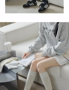Detail of light grey cotton calf socks paired with casual sneakers and loungewear