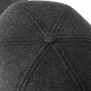 Makro-Detail der dunkelgrauen Wollmischung und Tweed-Textur einer Winter-Baseballkappe