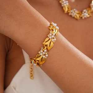 Detail of leaf-shaped golden bracelet with white pearls and sparkling zircons