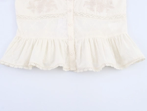 Gros plan détaillé des broderies et de la dentelle sur une blouse en coton beige
