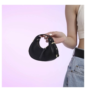 Close-up of black crescent leather handbag featuring elegant gold-tone metal hardware