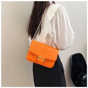 Detail of orange square shoulder bag with gold metal buckle and checkered stitching