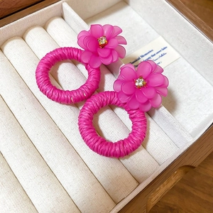 Detail of pink floral woven earrings with rhinestone centers in a velvet jewelry box