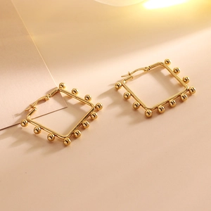 Detail of gold geometric square hoop earrings with small metal bead accents