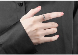 Close-up of a silver spinner ring with three beads worn on a finger for stress relief