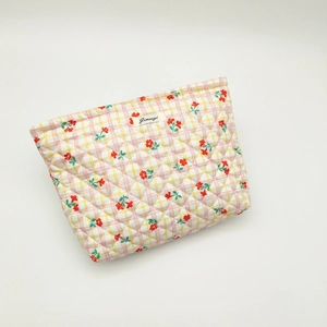 Quilted cotton makeup bag featuring red floral and yellow plaid patterns with a zipper