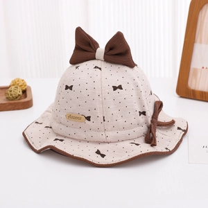 Detail of baby sun hat with brown polka dots and a large decorative knit bow
