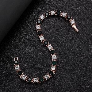 Vue détaillée du bracelet tennis en or rose avec zircons verts et blancs alternés