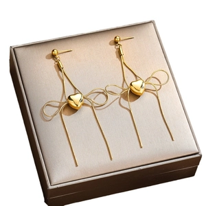 Elegant gold-plated heart-shaped tassel earrings on a premium metallic jewelry box