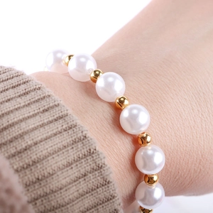Vue macro détaillée de perles blanches et de perles de séparation dorées sur le bracelet