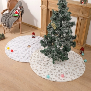 Detail of white and beige plush Christmas tree skirts with embroidered snowflake patterns