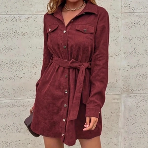Detailed close-up of burgundy corduroy shirt dress fabric texture and metal buttons