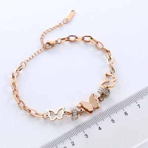 Bracelet papillon en acier inoxydable or rose avec breloques ajourées et perles