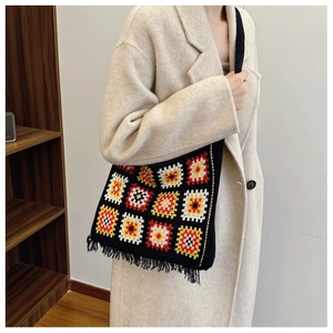 Detailed shot of a crochet knit tote bag with colorful granny squares and black tassels